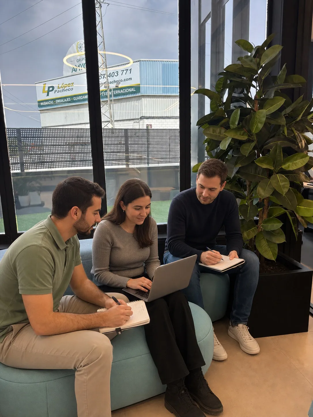 Profesionales de WAT trabajando juntos en la zona lounge de las oficinas